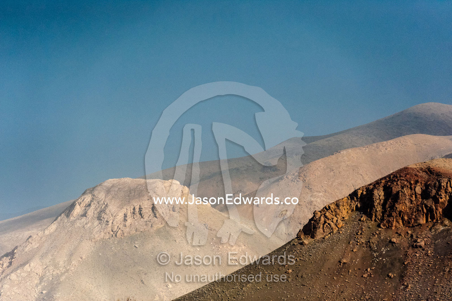 Sunrays illuminate the summits of barren desert mountains. Abyaneh, Barzrud Rural District, Natanz County, Isfahan Province, Islamic Republic of Iran.
