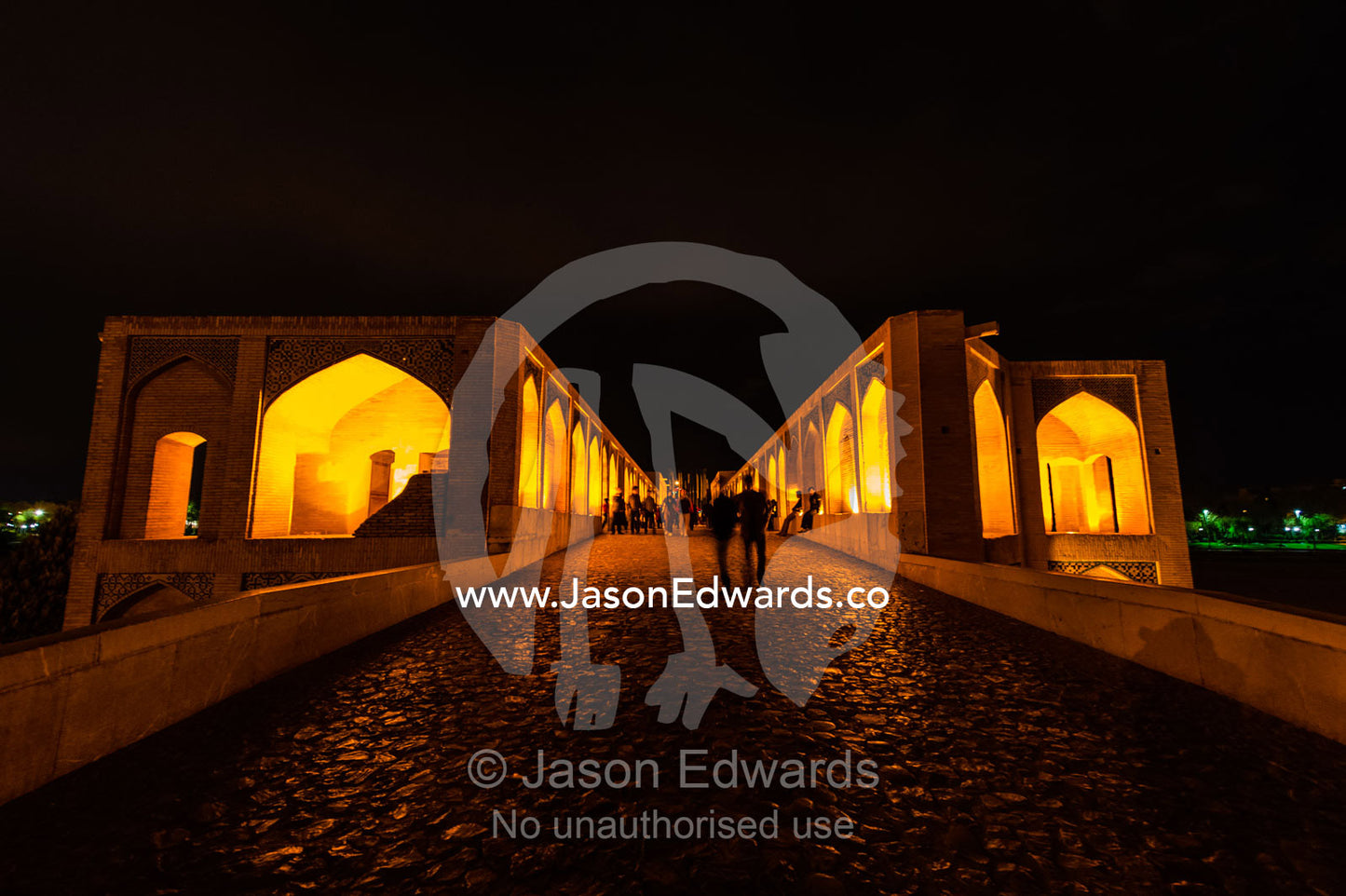 Light cascades from iwans lining the Khaju Bridge onto families and friends celebrating Nowruz Iranian New Year. Khaju Bridge, Isfahan, Isfahan Province, Islamic Republic of Iran.