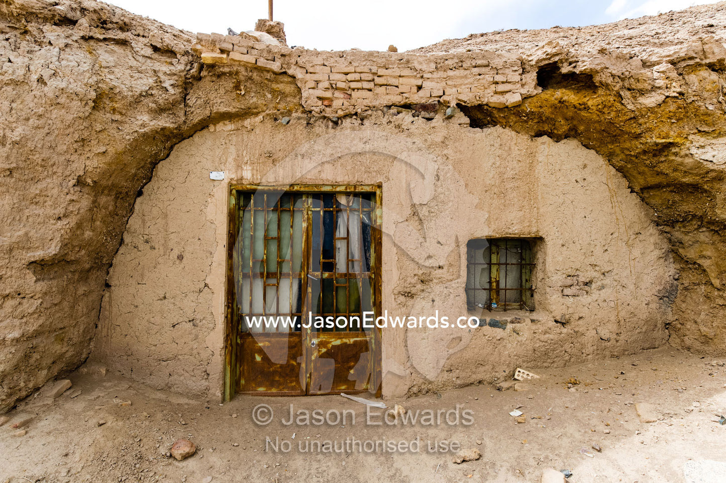 The stone facade of a traditional cloak weaving workshop buried underground in the desert. Nain, Nain County, Isfahan Province, Iran.