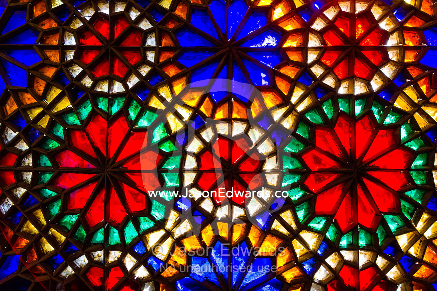 Sunlight pours through colourful stained glass windows lighting the interior of the residence. Dowlat Abad Garden, Yazd, Yazd Province, Islamic Republic of Iran.