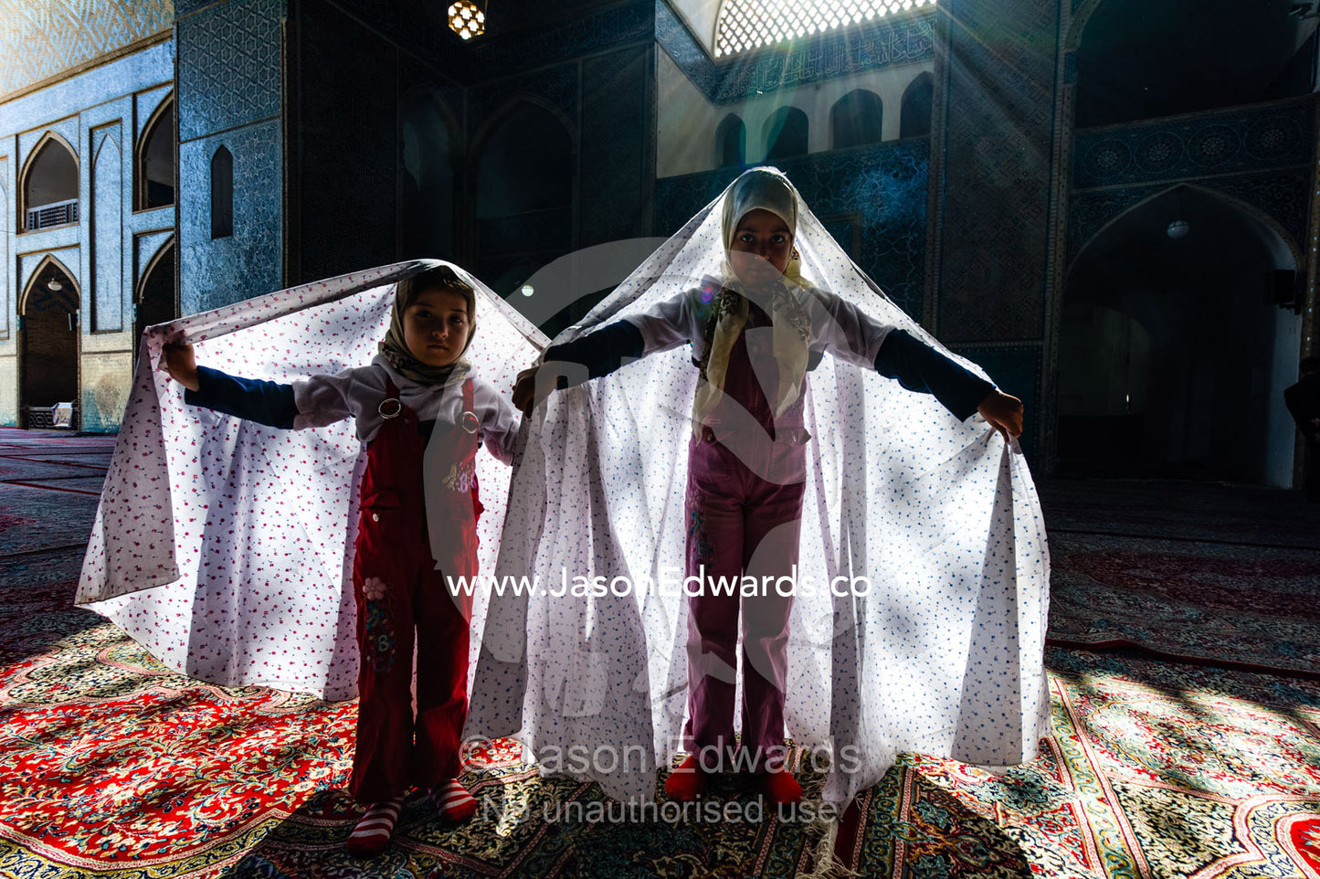 Girls wearing white chador covered in flowers whilst visiting a mosque during Nowruz Iranian New Year. Jame Mosque of Yazd, Yazd, Yazd Province, Islamic Republic of Iran.