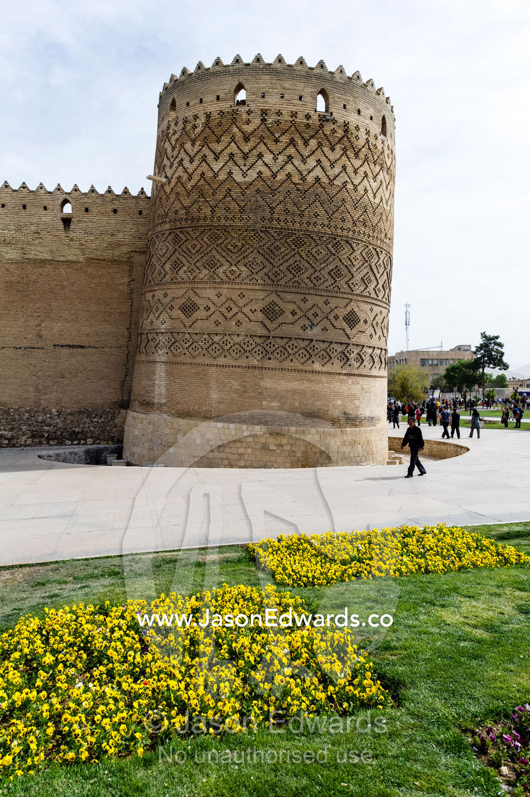 The steep walls and tower of the Karim Khan Castle surrounded by garden beds. Karim Khan Castle, Shiraz, Fars Province, Islamic Republic of Iran.