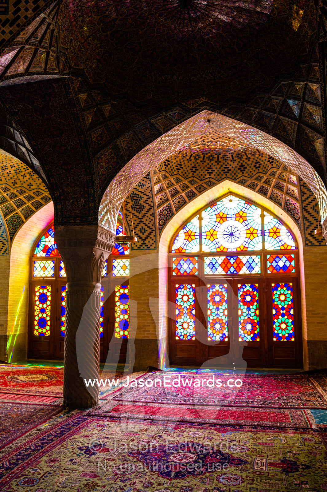 Sunlight pours through colourful stained glass windows lighting the interior of the mosque. Nasir ol Molk Mosque, Shiraz, Fars Province, Islamic Republic of Iran.