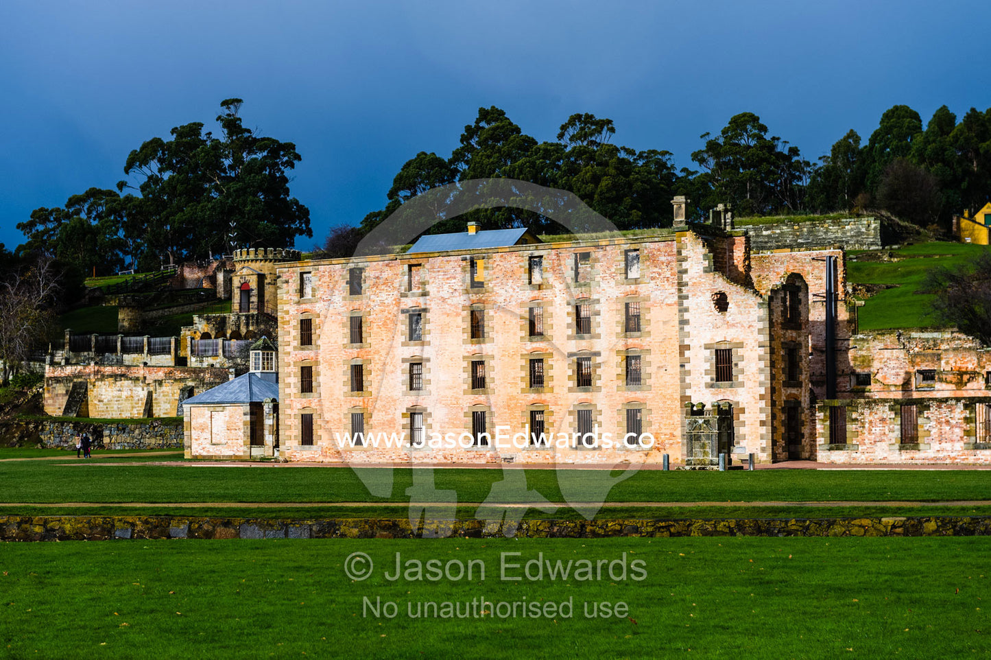 The facade and barred windows of the Port Arthur penitentiary overlooking a manicured lawn. Port Arthur Historic Site, Port Arthur, Tasmania,
Australia