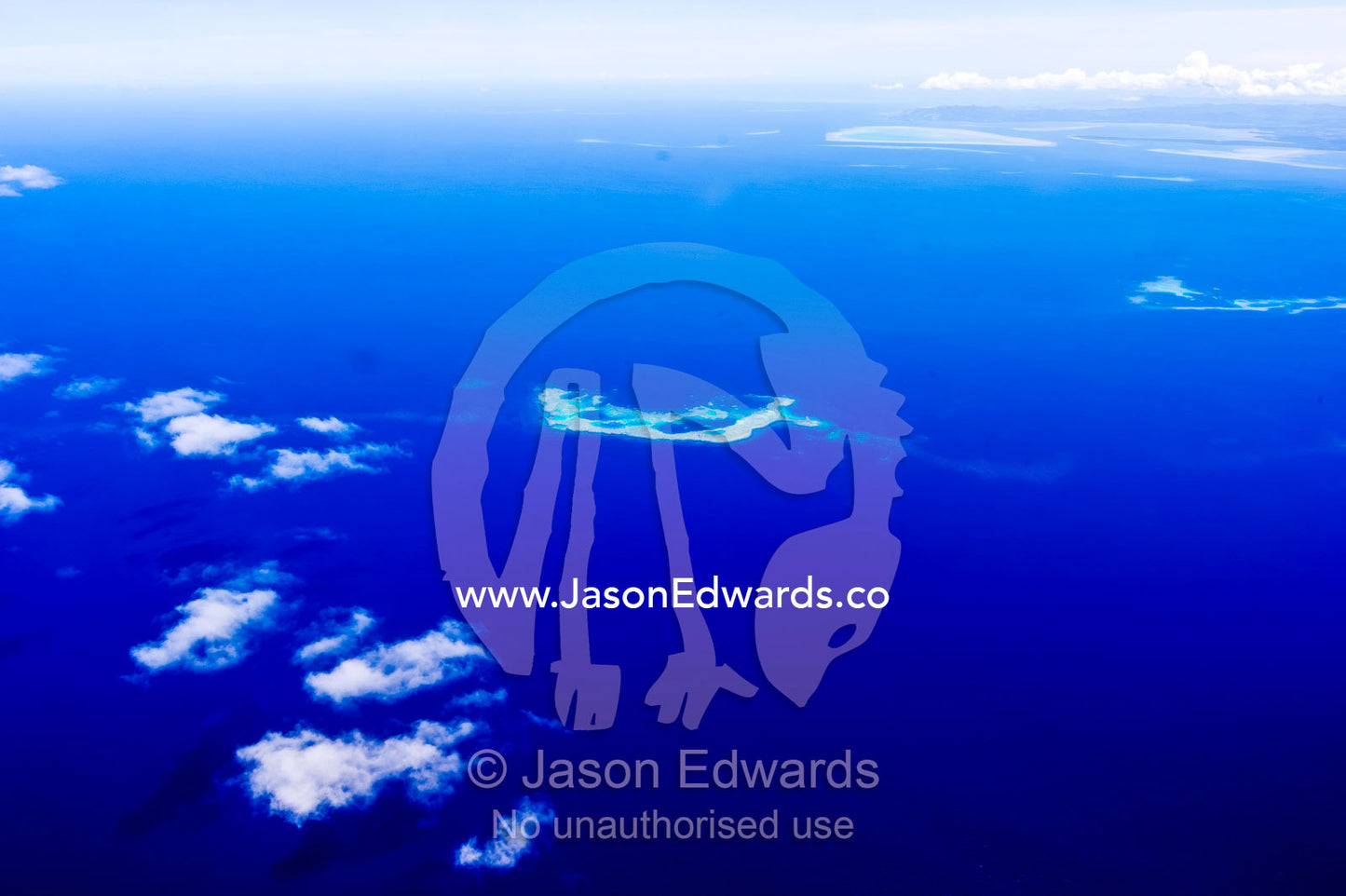 Clouds floating over a deep blue tropical ocean with isolated sandbars. Taveuni Island, Somosomo Strait, Pacific Ocean, Fiji Islands.