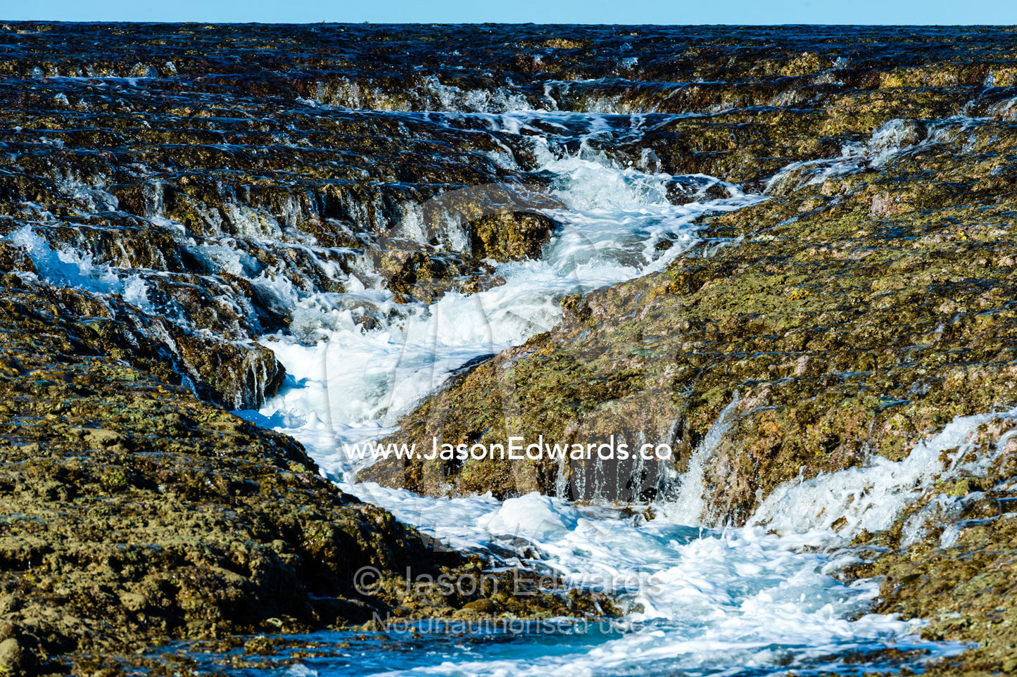 Water cascades from the surface of an exposed coral reef at low tide. Montgomery Reef, Camden Sound, Kimberley Coast, Western Australia, Australia.