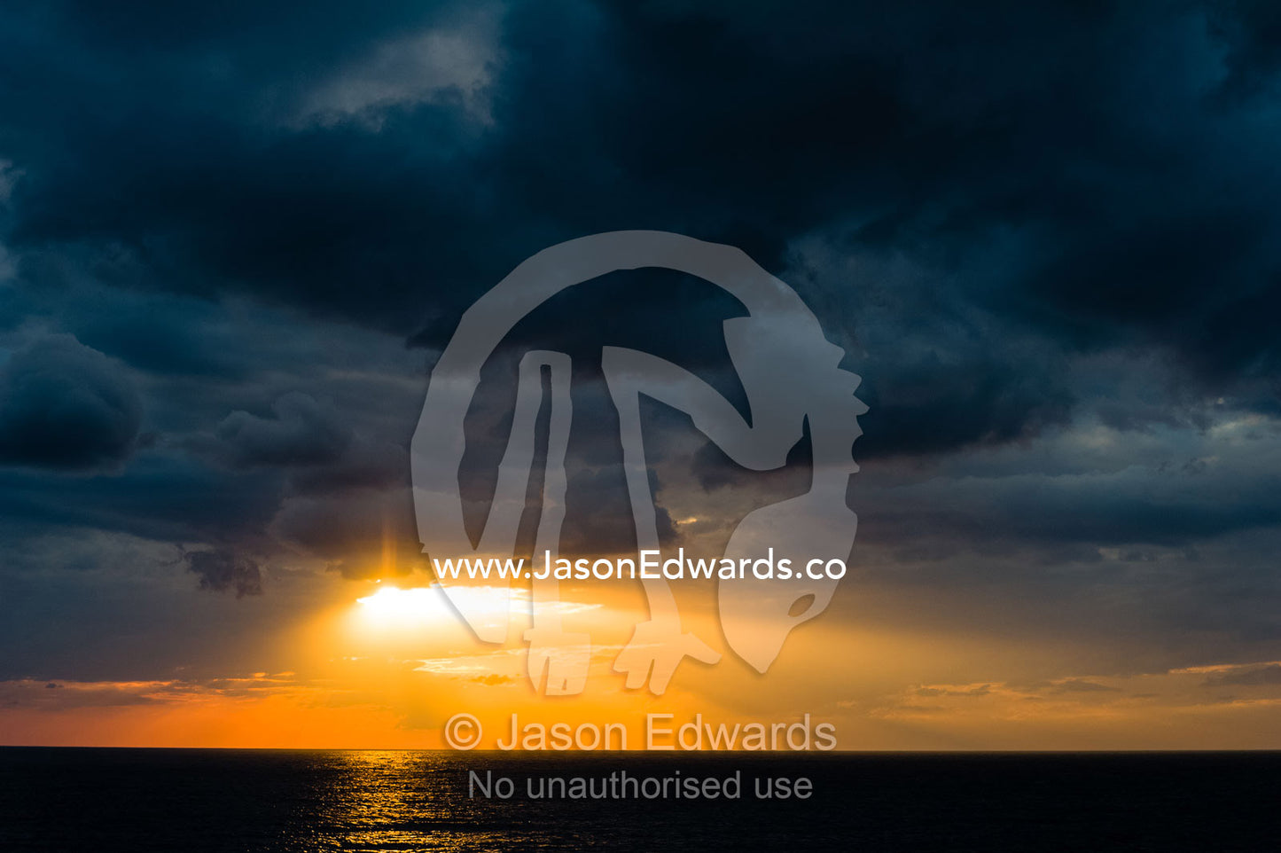 Sunrays pierce ominous storm clouds over a calm tropical ocean. Joseph Bonaparte Gulf, Bonaparte Gulf, Com, Sunda Islands, Timor-Leste, East Timor.