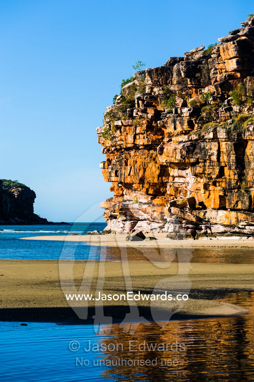 Sandstone cliffs on a remote and pristine coastal desert beach. Calamity Bay, Koolama Bay, Kimberley Coast, Western Australia, Australia.