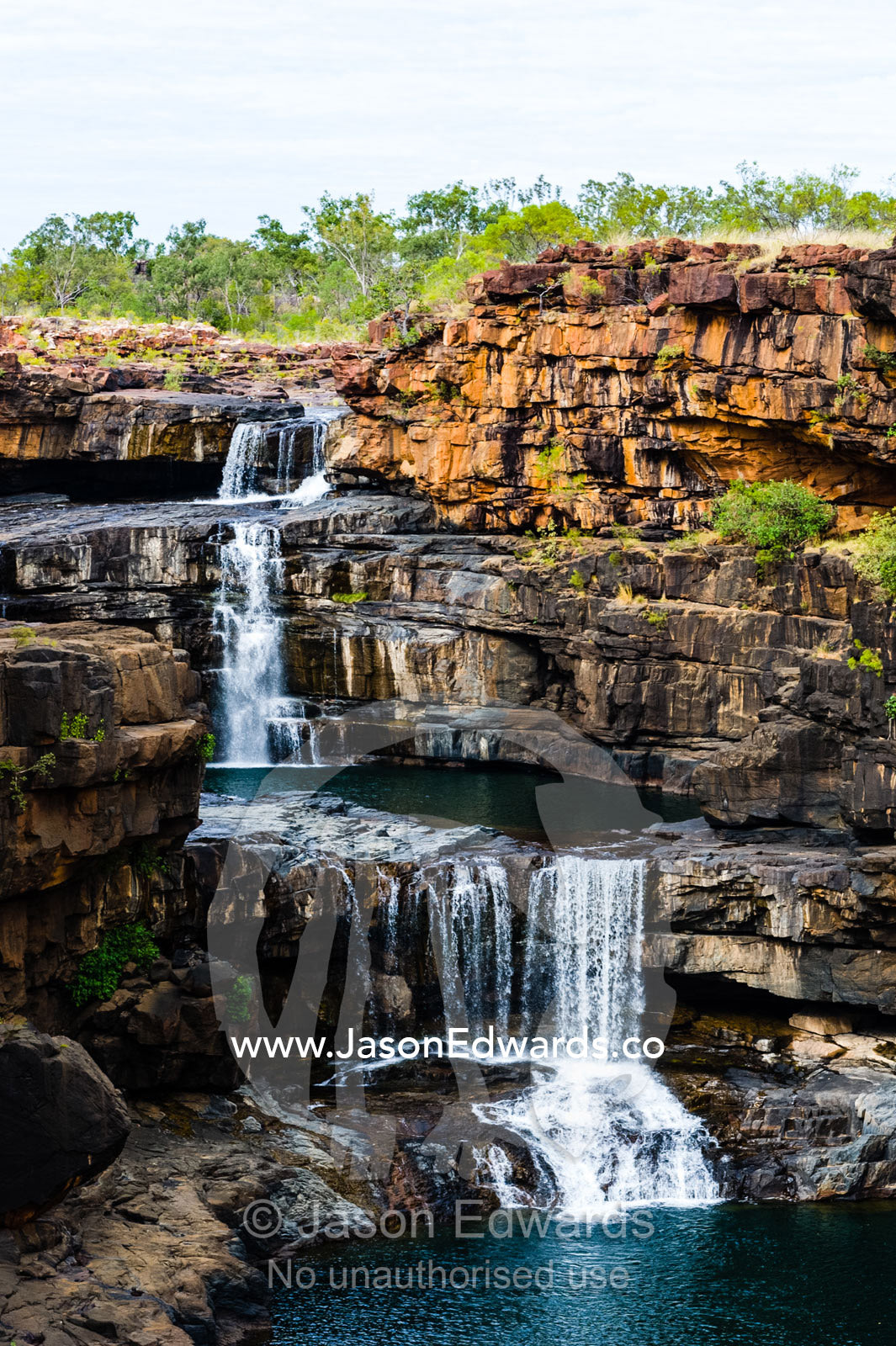 The magnificent Mitchell River cascades down ochre sandstone tiers in multiple waterfalls. Mitchell Falls, Mitchell River National Park, Mitchell Plateau, Kimberley Coast, Western Australia, Australia.