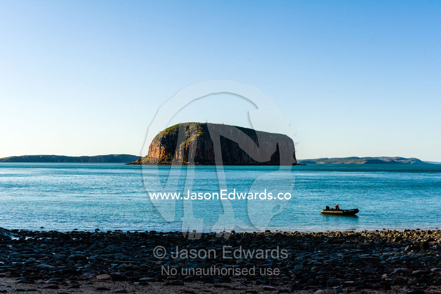 A solitary dingy on the shore if an uninhabited beach at sunset. Raft Point, Doubtful Bay, Buccaneer Archipelago, Kimberley Coast, Western Australia, Australia.
