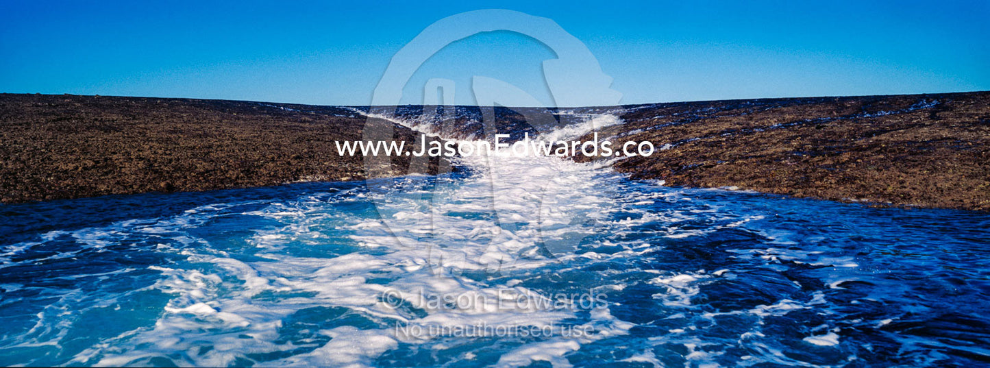 Water cascades from the surface of an exposed coral reef at low tide. Montgomery Reef, Camden Sound, Kimberley Coast, Western Australia, Australia.