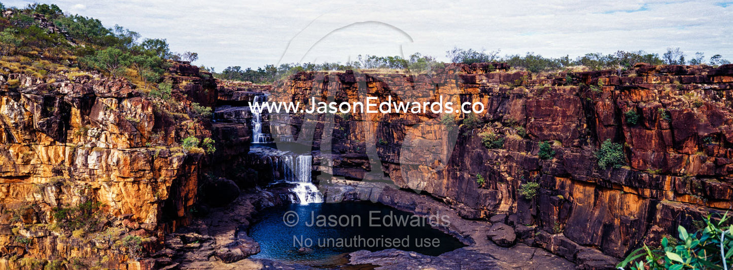 The magnificent Mitchell River cascades down ochre sandstone tiers in multiple waterfalls. Mitchell Falls, Mitchell River National Park, Mitchell Plateau, Kimberley Coast, Western Australia, Australia.
