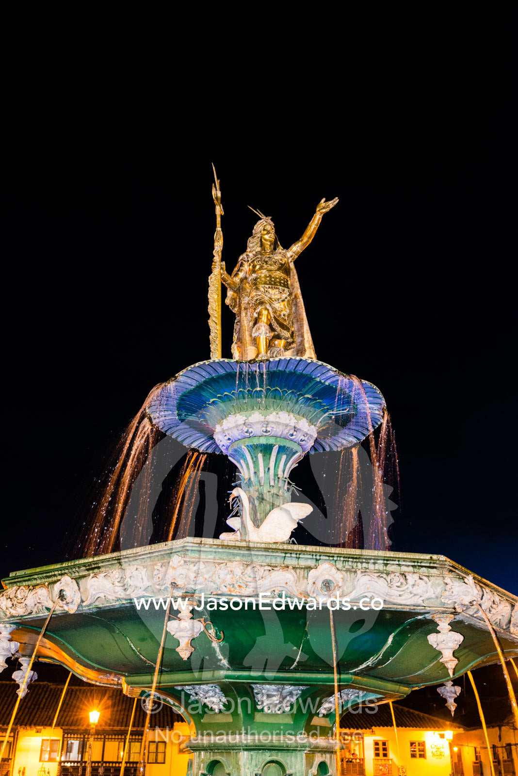 The Inca Pachacutec Fountain illuminated at night in the Plaza de Armas. Cusco, Peru.
