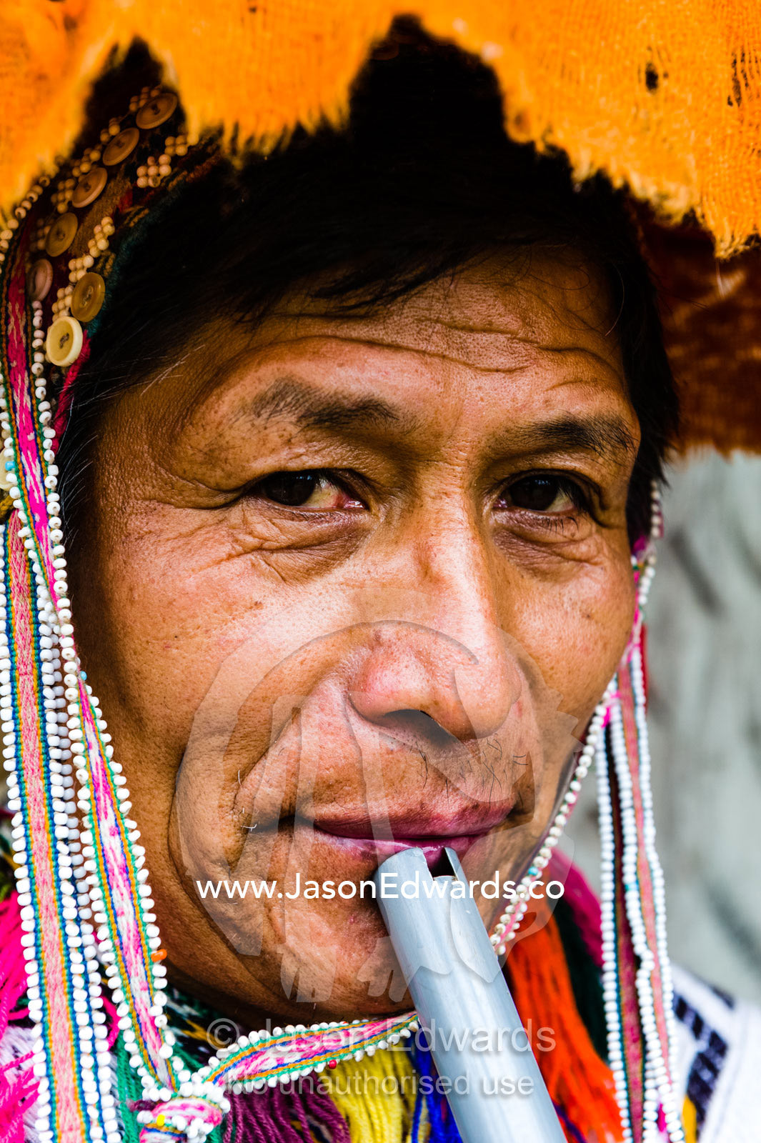 An Amaru man playing a ceremonial flute wearing a montera. Peru.