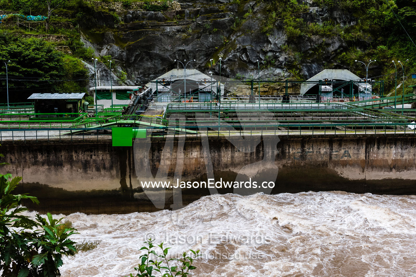 River rapids flow past a hydroelectricity power station in the Andes mountains. Peru.