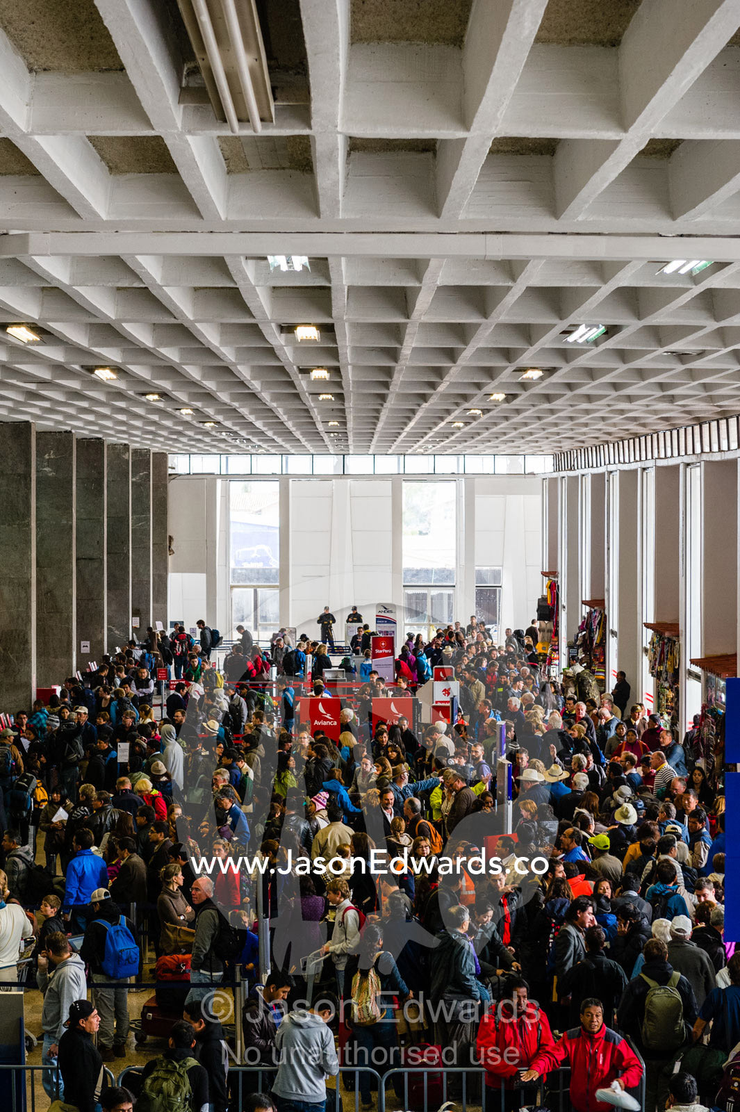 Crowds of people waiting to check in at an airport. Cusco, Peru.
