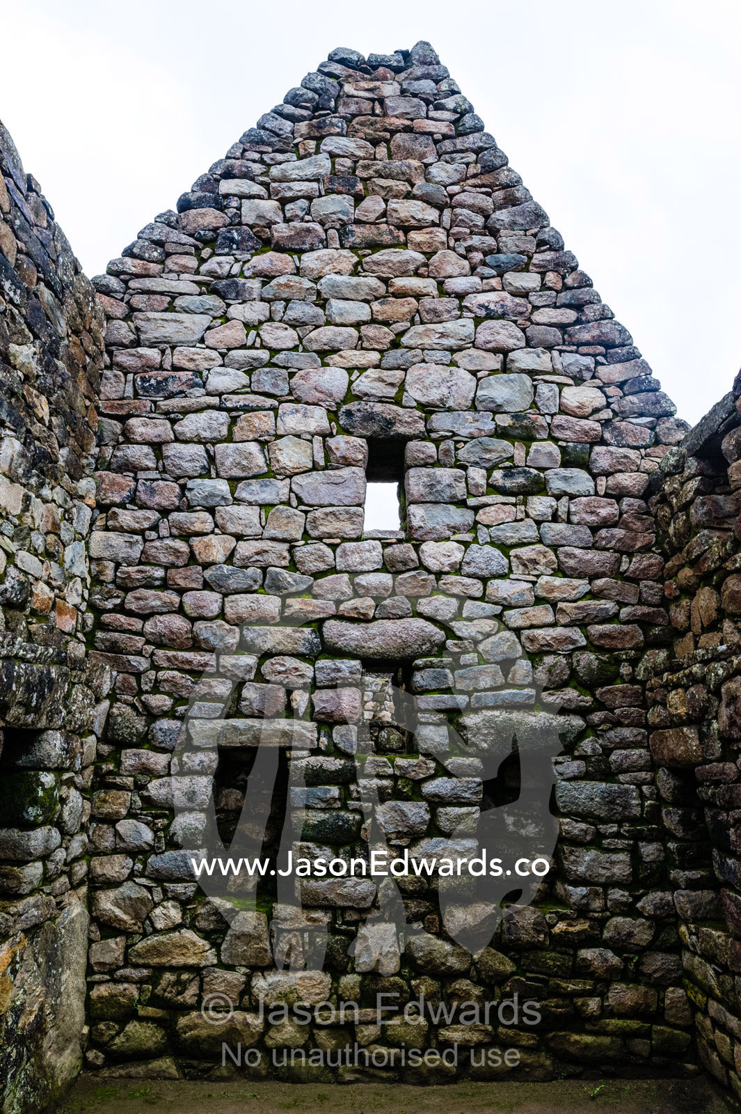 A window in a trapezoidal wall in a residential building at Macchu Picchu. Peru.