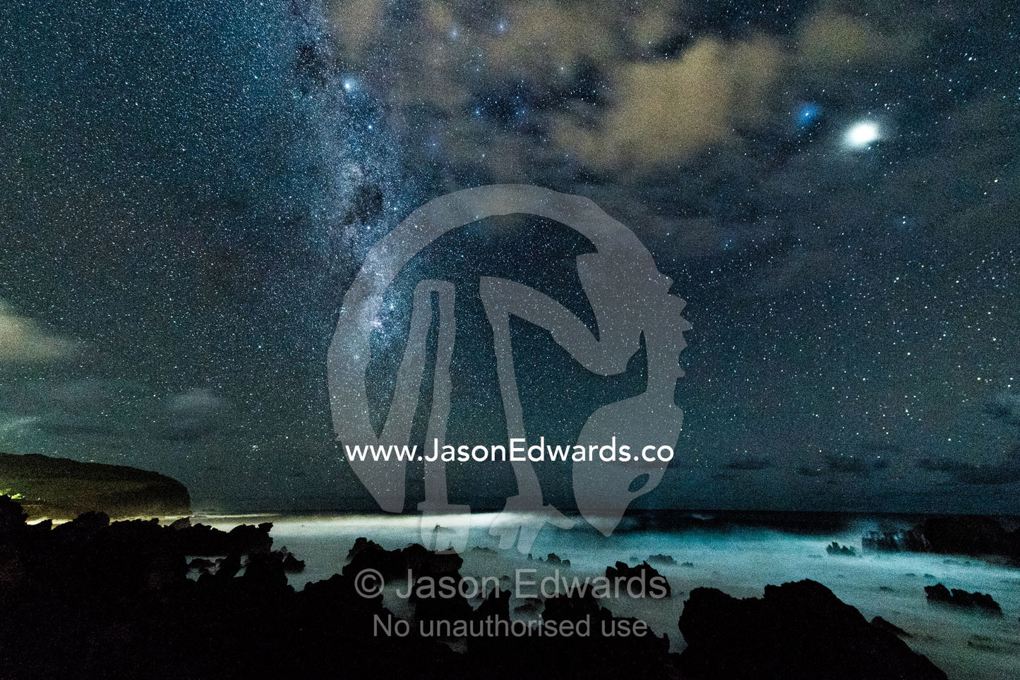 The Milky Way Galaxy rises over a volcanic coastline on the Pacific Ocean. Hanga Roa Eco Village, Rapa Nui, Easter Island, Chile
