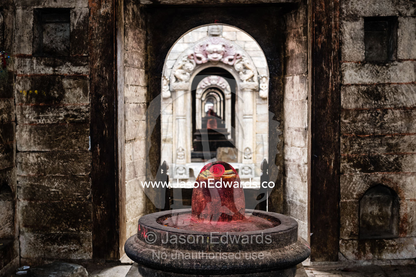 A lingam, non-anthropomorphic representation of the Hindu god Shiva in his generative aspect, stained red with puja powder known as kumkuma. Kathmandu, Pashupatinath Temple, Nepal