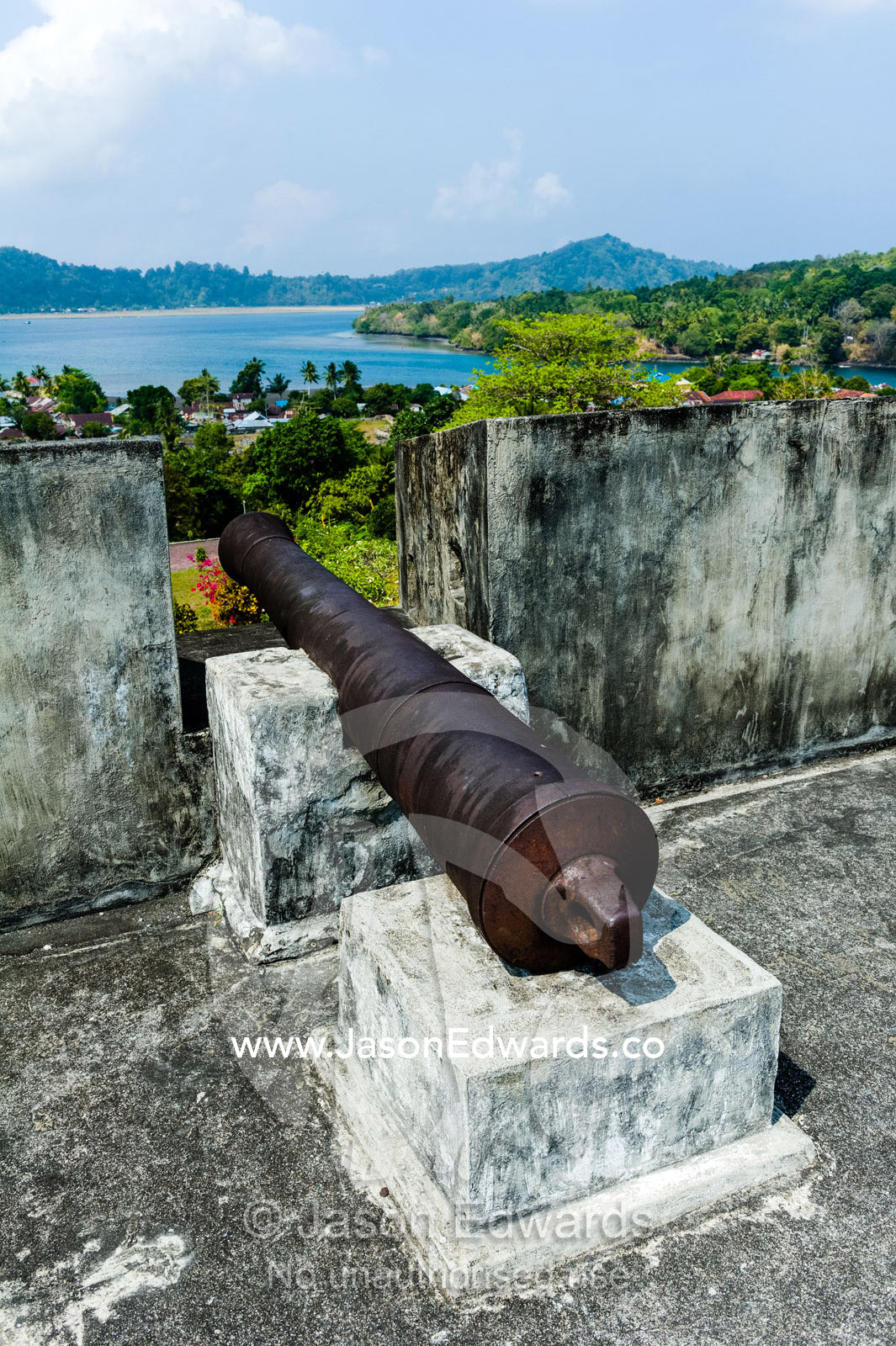 An antique cannon defends a Dutch colonial fort on a tropical island. Fort Belgica, Banda Neira, Banda Islands, West Papua, Indonesia