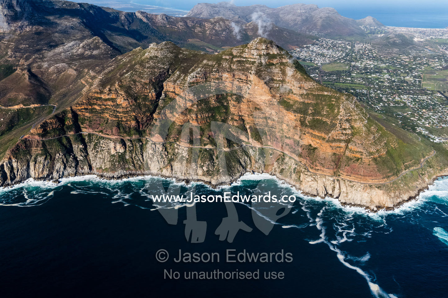 The winding road of Chapmans Peak Drive passes beneath sheer cliffs. Table Mountain National Park, South Africa