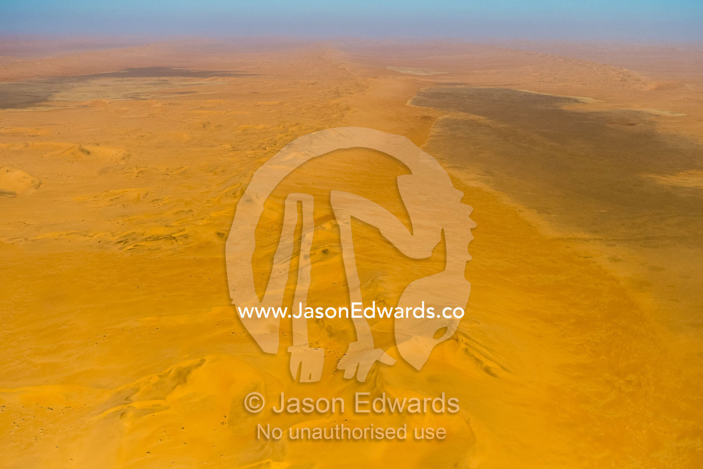 An aerial view of a sea of sand dunes disappearing into the distant horizon. Namib Desert, Diamond Coast, Skeleton Coast, Namib-Naukluft National Park, Namibia