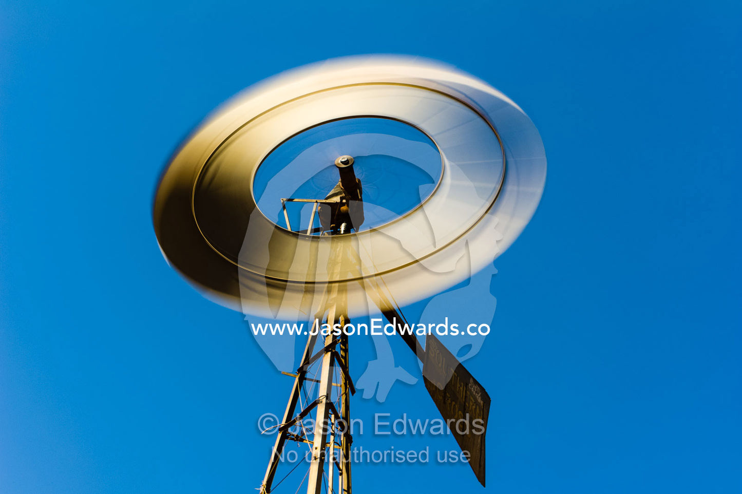 The blades of a windmill spinning in the wind on a remote outback cattle station in the desert. Coober Pedy, Wintinna Station, South Australia, Australia