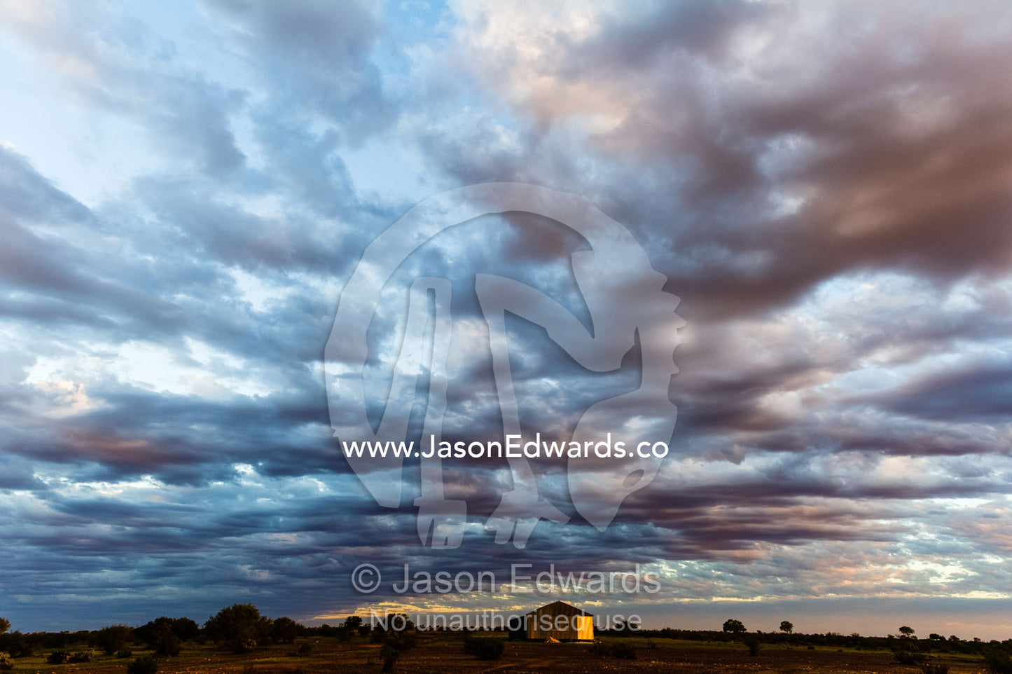 Storm clouds roll in over a shearing shed on an outback sheep station in the desert. Coober Pedy, Mt Willoughby Station, South Australia, Australia