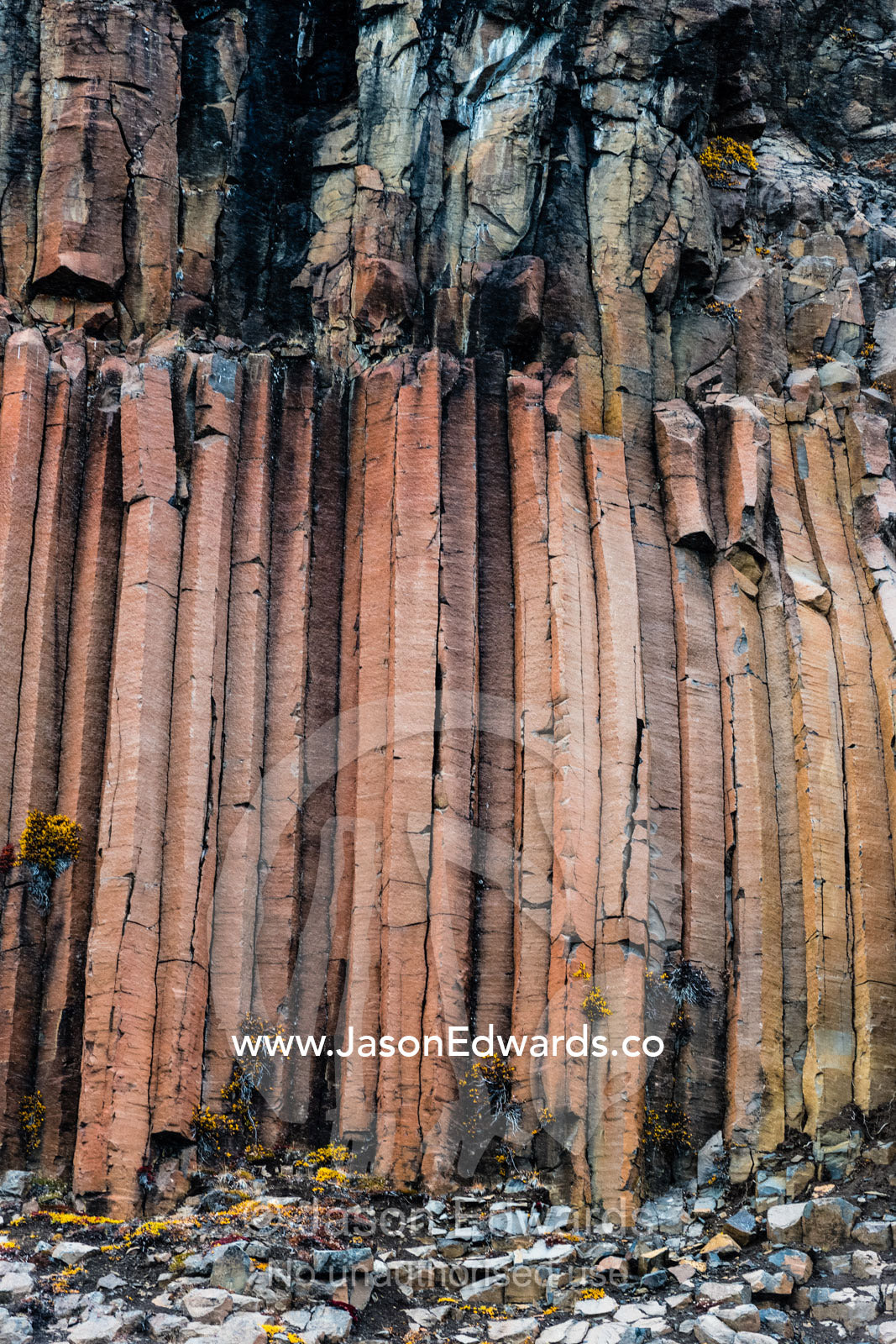 Hexagonal lava basalt column formations rising up a sheer cliff face in the arctic Vikingbukt, Viking Bay, Vikingbukta, Scoresby Sound, Greenland