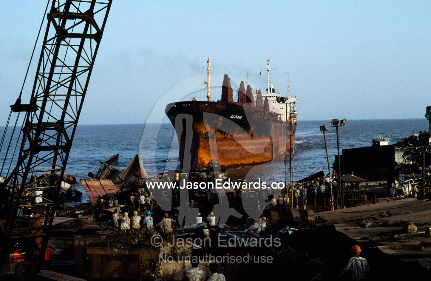 Workers in a shipyard get ready to reclaim the steel on this ship. Alang, India.