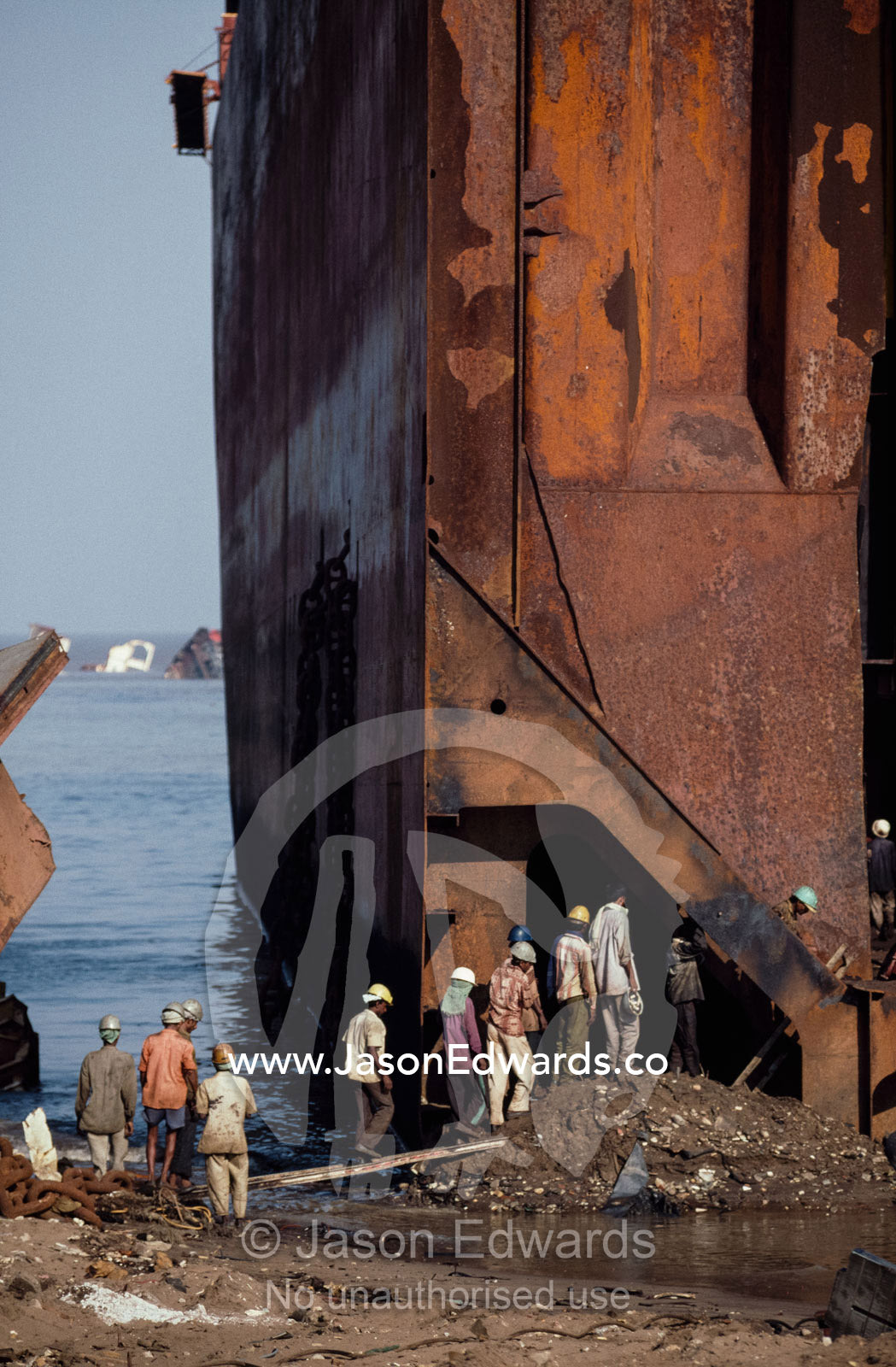 Workers file into the darkness of a tanker's cargo hold. Alang, India.