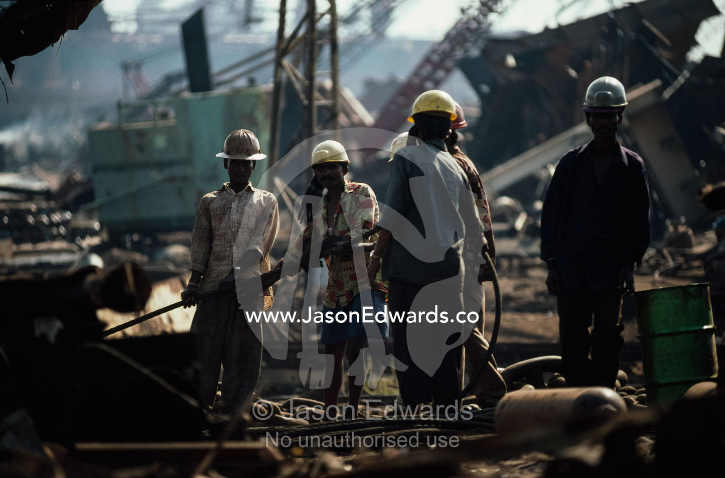 Workers haul on a cable that winches a ship further onto the beach Alang, India.