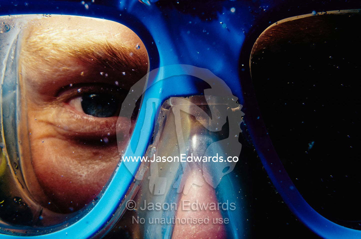 A close view of a diver's face behind diving goggles. Merimbula, New South Wales, Australia.