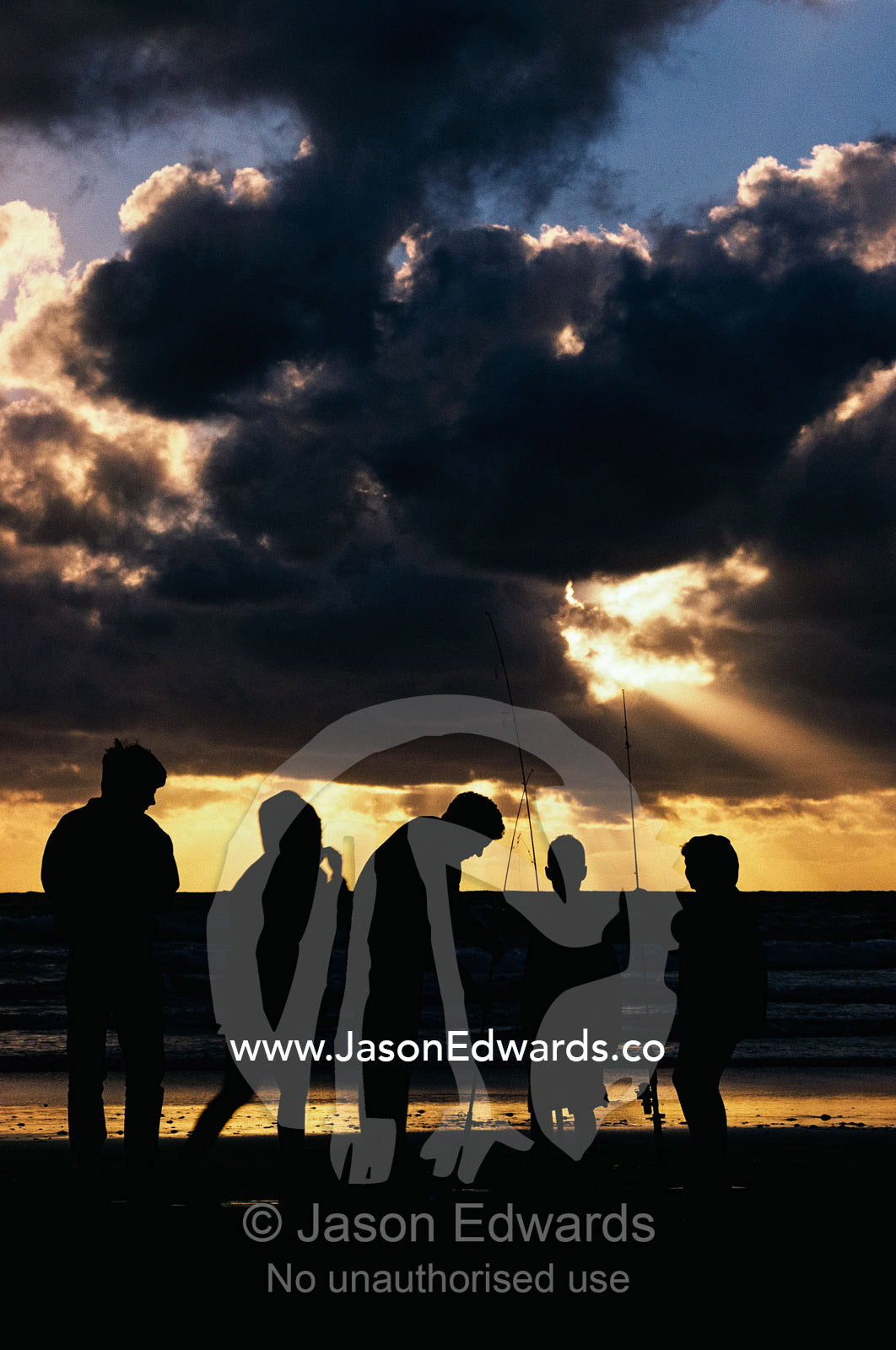 Silhouetted fishermen on the shore at twilight. Wilsons Promontory National Park, Victoria, Australia.