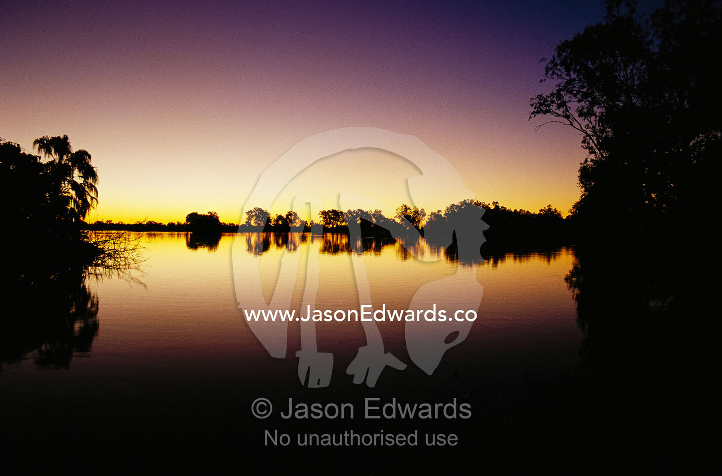 View at sunset of silhouetted offshore islands in a wetland lagoon. Murray Lagoon, Fitzroy River, Queensland, Australia.