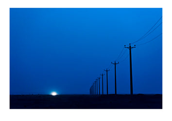 Electricity poles crossing a vast and lonely desert plain at night. Abyaneh, Barzrud Rural District, Natanz County, Isfahan Province, Islamic Republic of Iran.