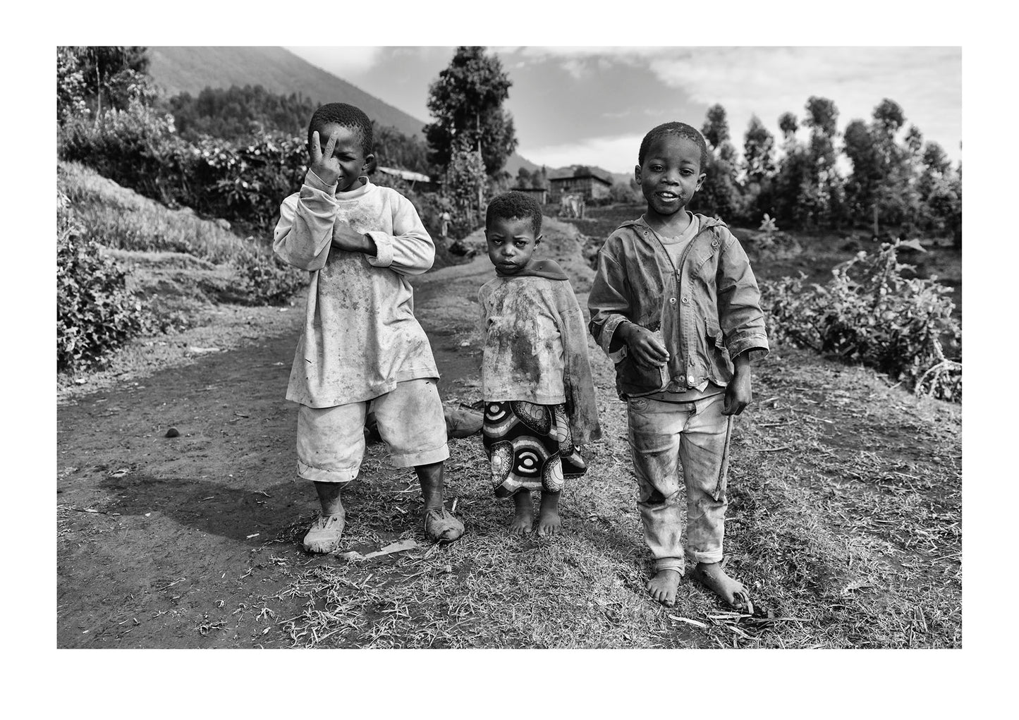 Curious boys in a village greet hikers on their way to see endangered Mountain Gorillas. Volcanoes National Park, Parc National des Volcans Rwanda.