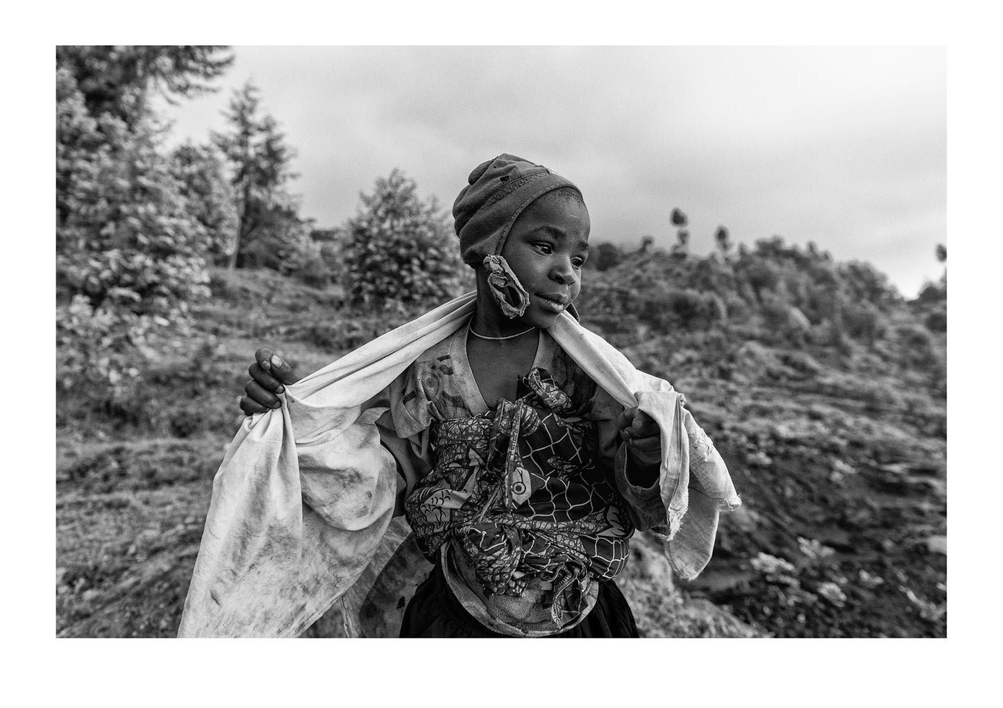 A girl in a village working on a farm near endangered Mountain Gorillas. Volcanoes National Park, Parc National des Volcans Rwanda.