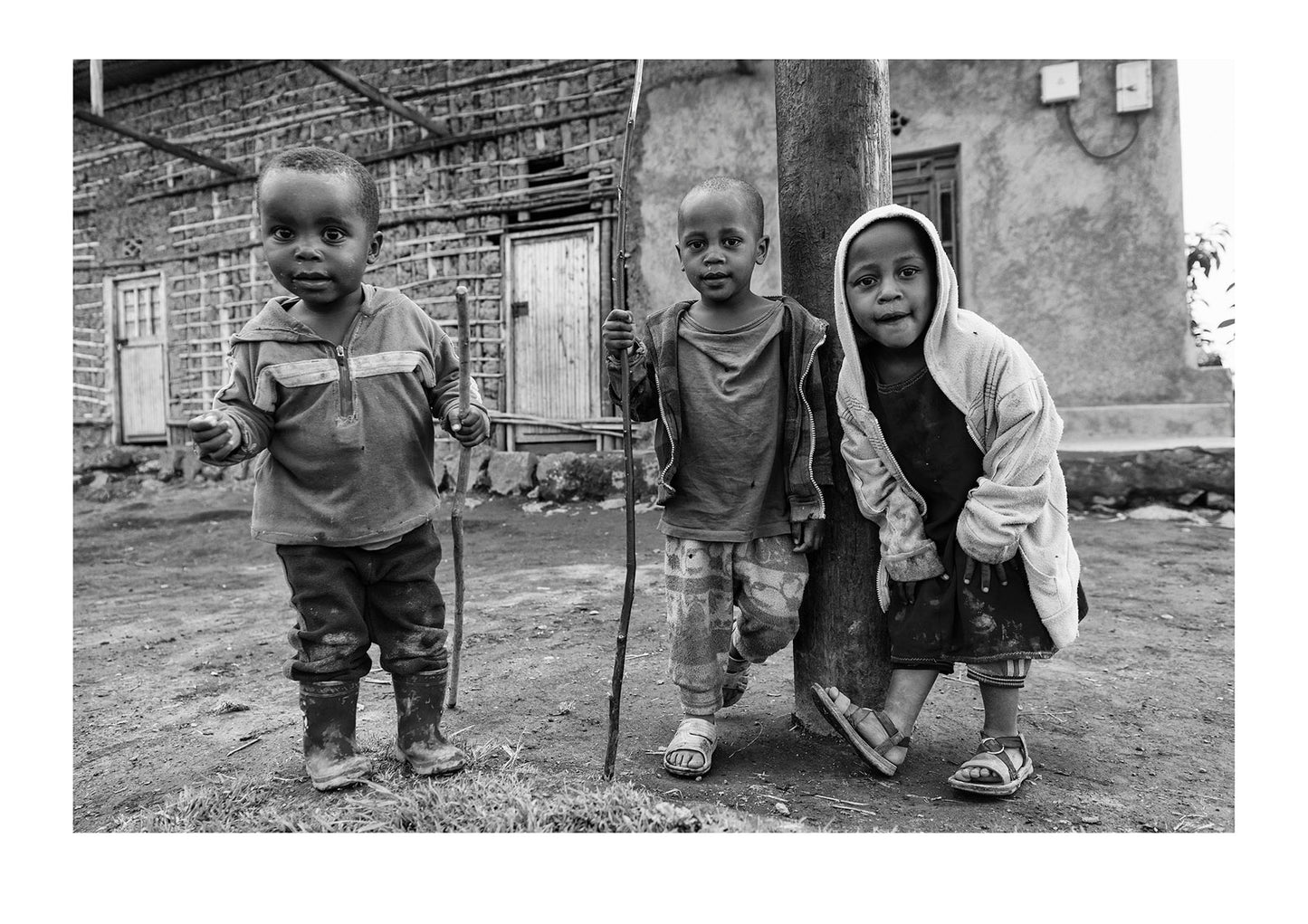 Curious boys in a village greet hikers on their way to see endangered Mountain Gorillas. Volcanoes National Park, Parc National des Volcans Rwanda.