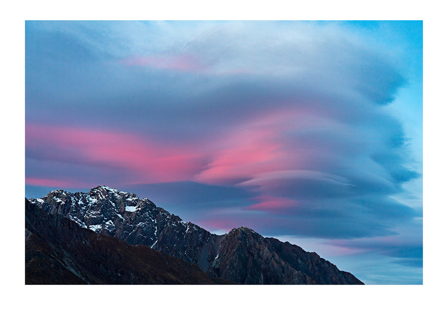 This wonderful formation looming over a jagged peak is calla lenticular cloud. They give off the appearance of calmness however they can be quite dangerous. New Zealand.