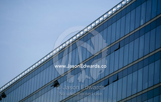 Sky reflected in the glass windows of a modern office building. Berlin, Germany.
