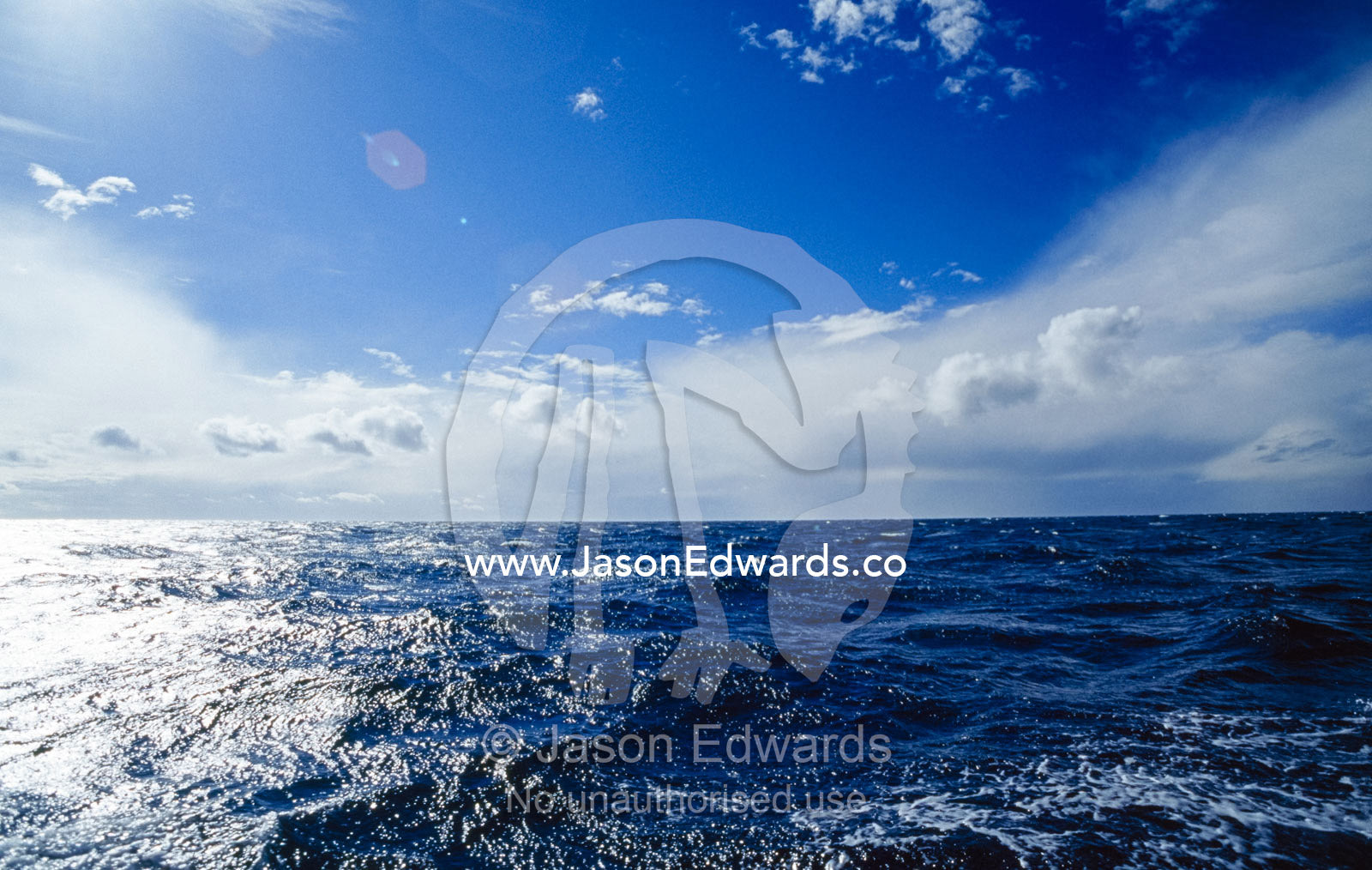 Storm clouds and sunlight reflecting off a turbulent ocean. Twofold Bay, Eden, New South Wales, Australia.