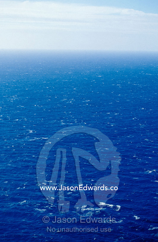 Wind creates white-capped waves sprinkled across a vast blue ocean. Bass Strait, Victoria, Australia.