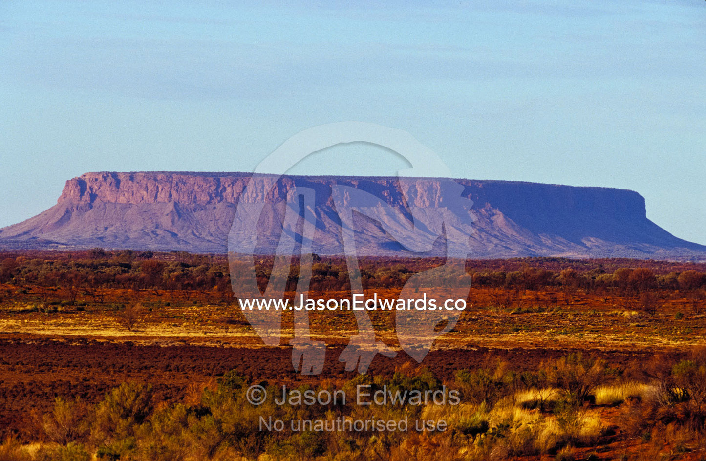 Mount Conner's table-top plateau is visible far across the arid plain. Mount Conner, Northern Territory, Australia.