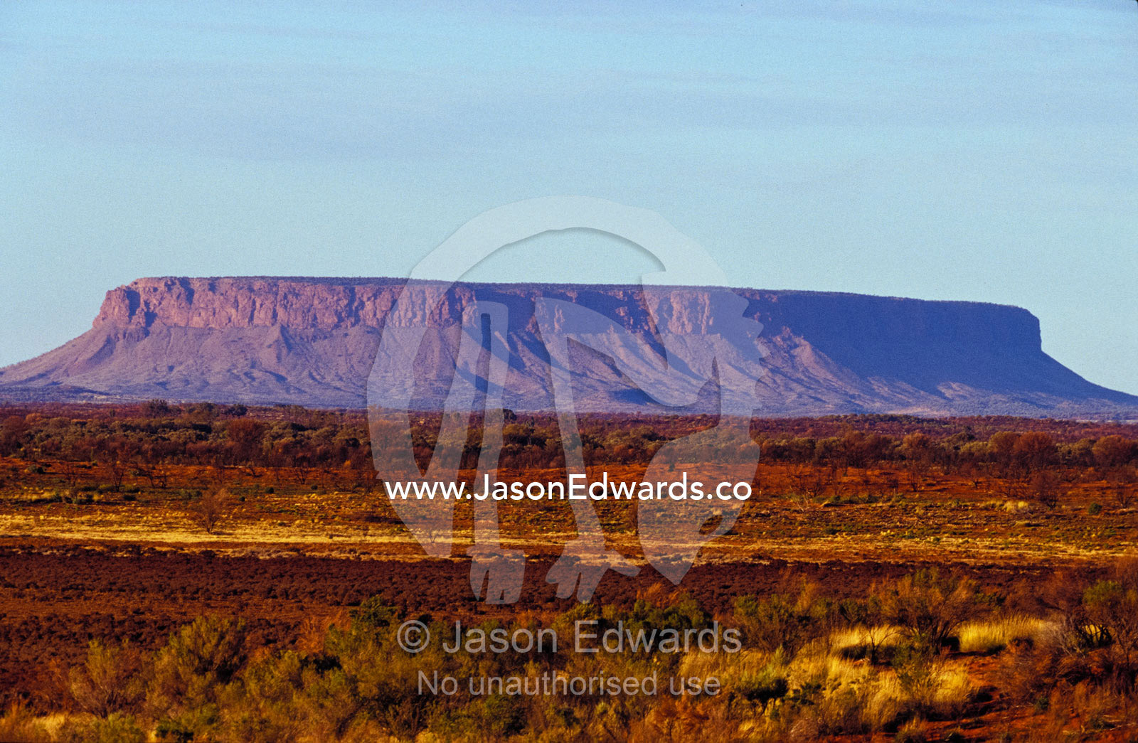 Mount Conner's table-top plateau is visible far across the arid plain. Mount Conner, Northern Territory, Australia.