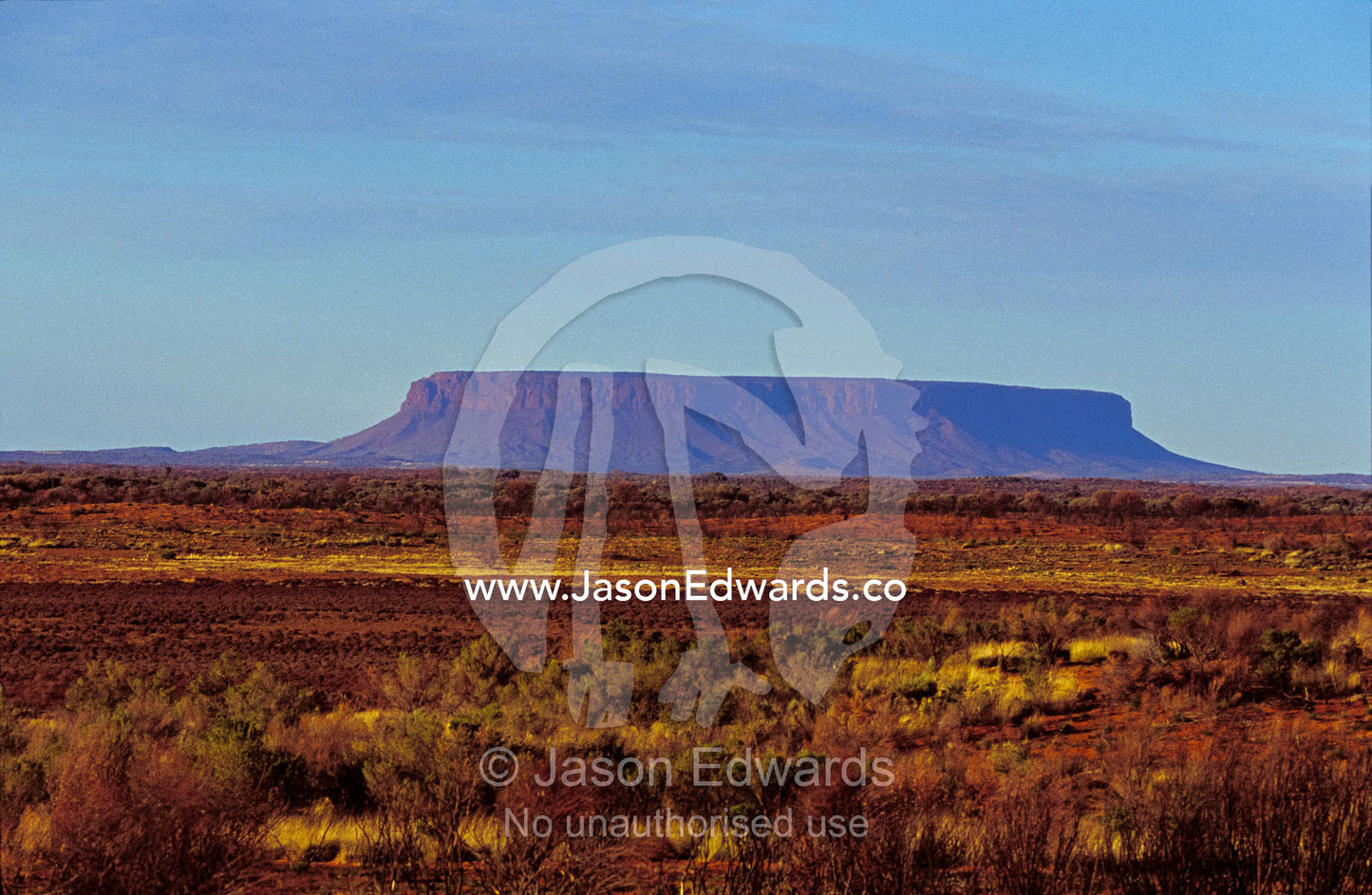 Dawn at Mount Conner overlooking a vast, arid desert plain. Mount Conner, Northern Territory, Australia.
