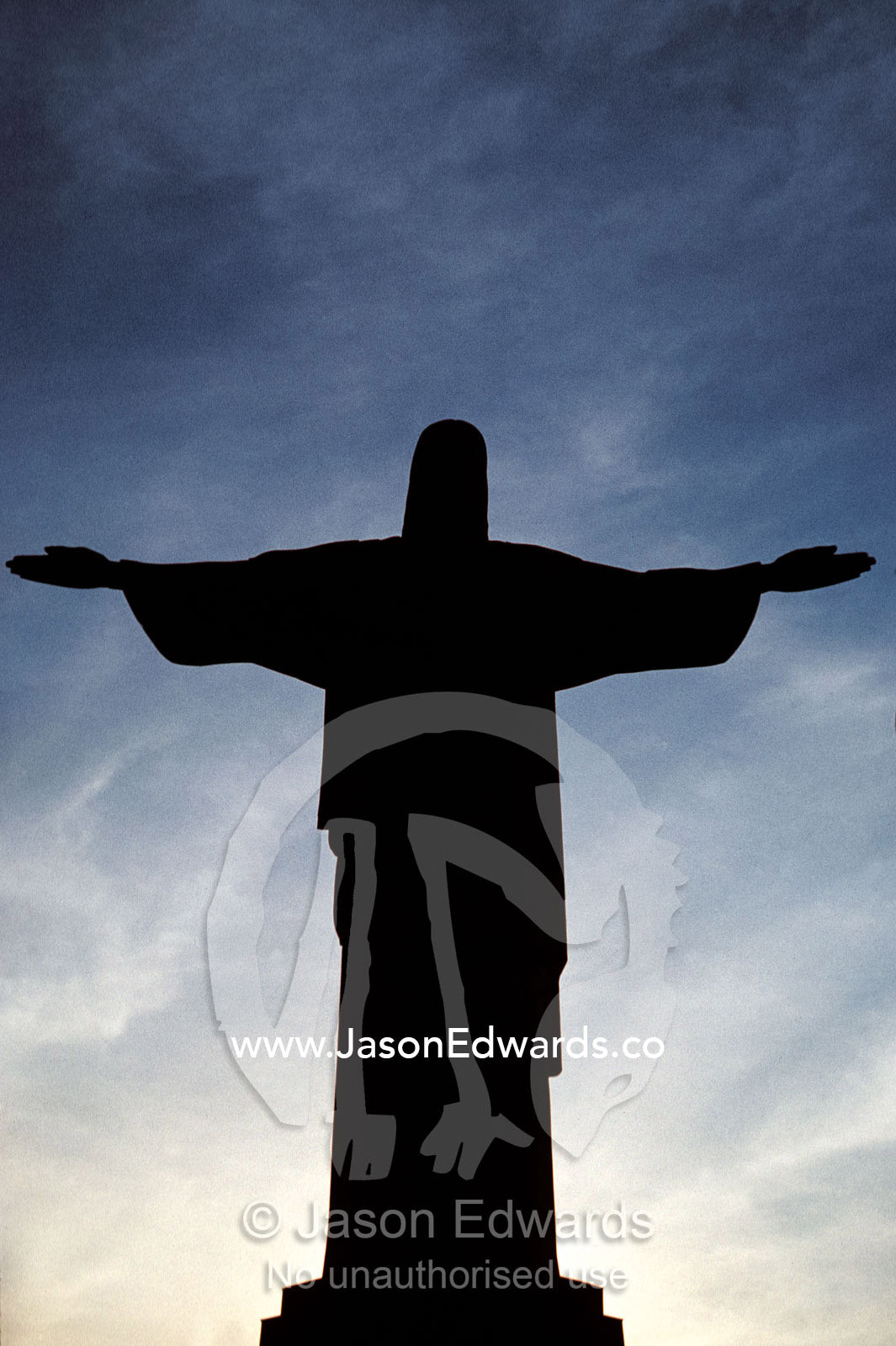 Statue San Cristova, Christ, silhouetted with flood lights at sunset. Rio de Janiero, Brasil, Brazil.