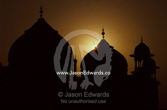 Taj Mahal mosque domes and turrets silhouetted at sunset. Taj Mahal, Agra, India.