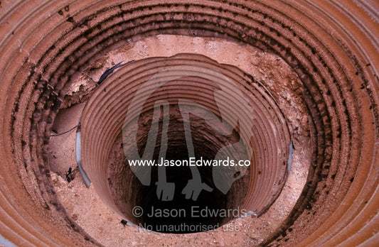 Circular tunnel entrance to an underground opal mine air shaft. Coober Peedy, South Australia.