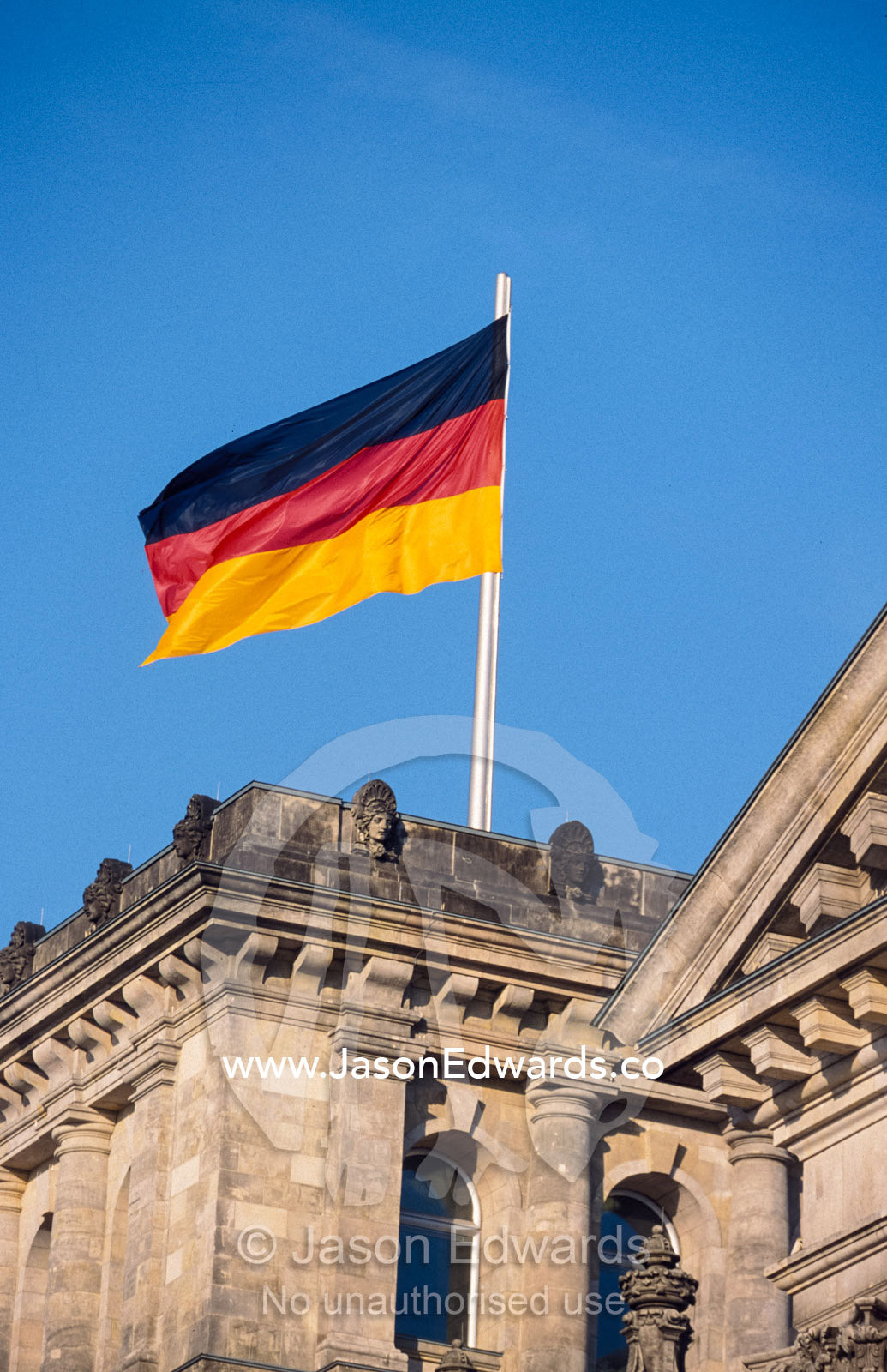 The German flag flies high above the new Reichstag in Berlin. Berlin, Brandenburg, Germany.